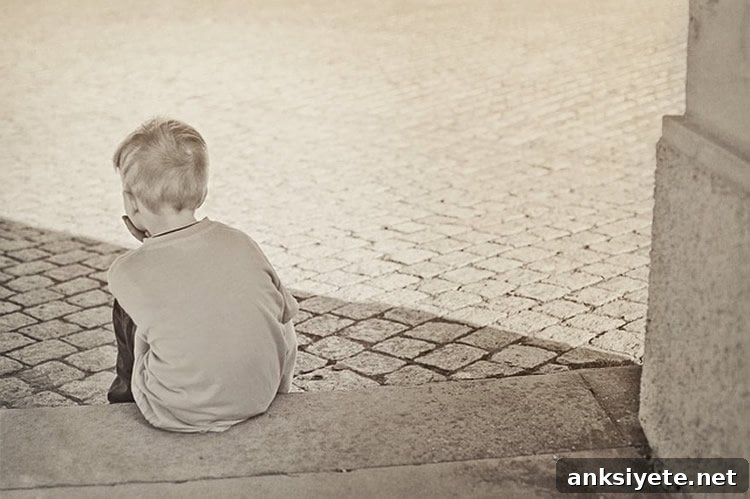 Image shows small child sitting on some steps.