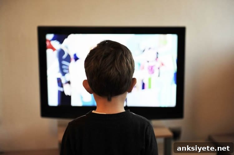 Image shows a boy watching TV.