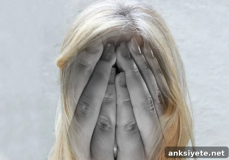 Image shows a woman holding her head in pain.
