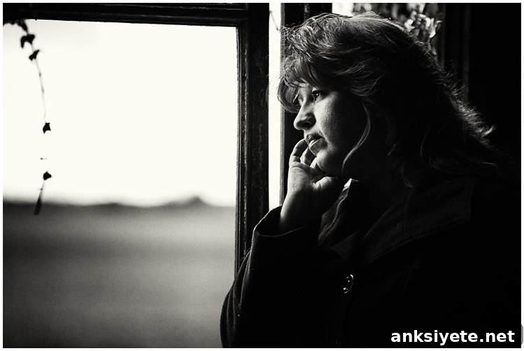 A woman standing at a window, symbolic of reflection and memory