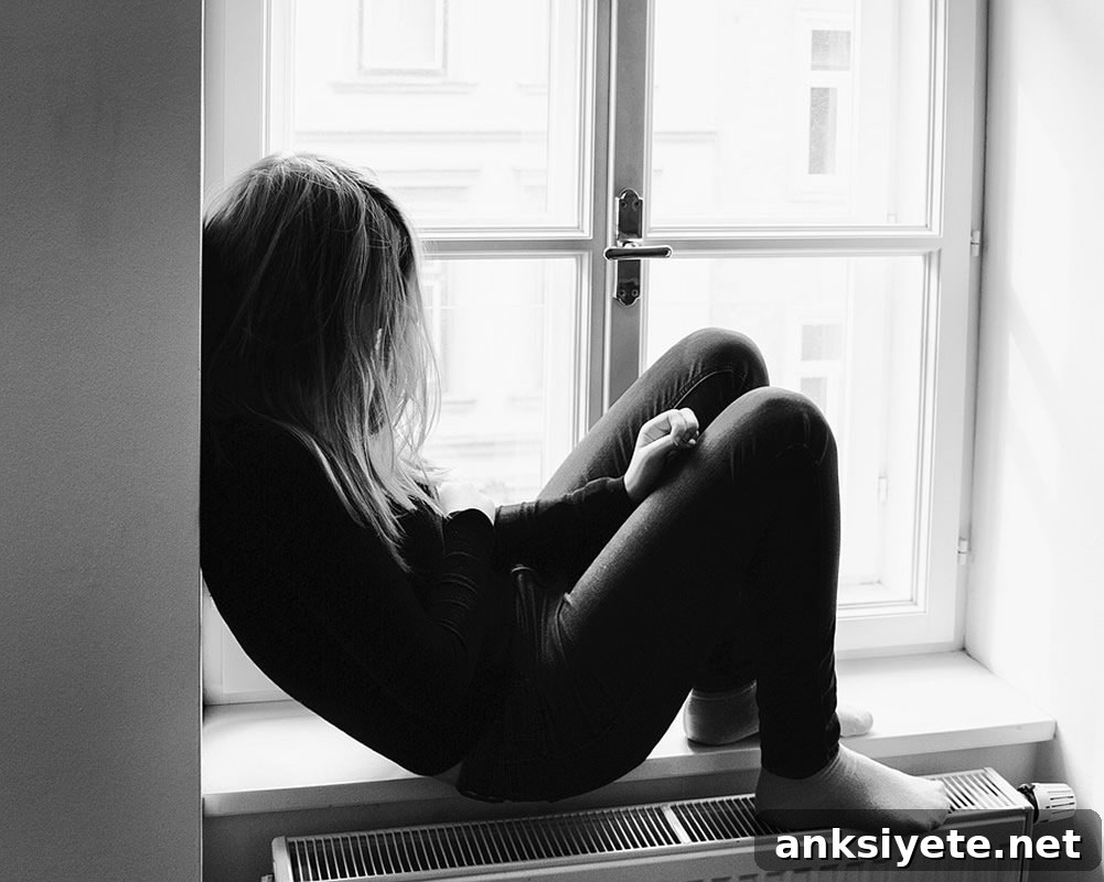This shows a depressed girl sitting by a window