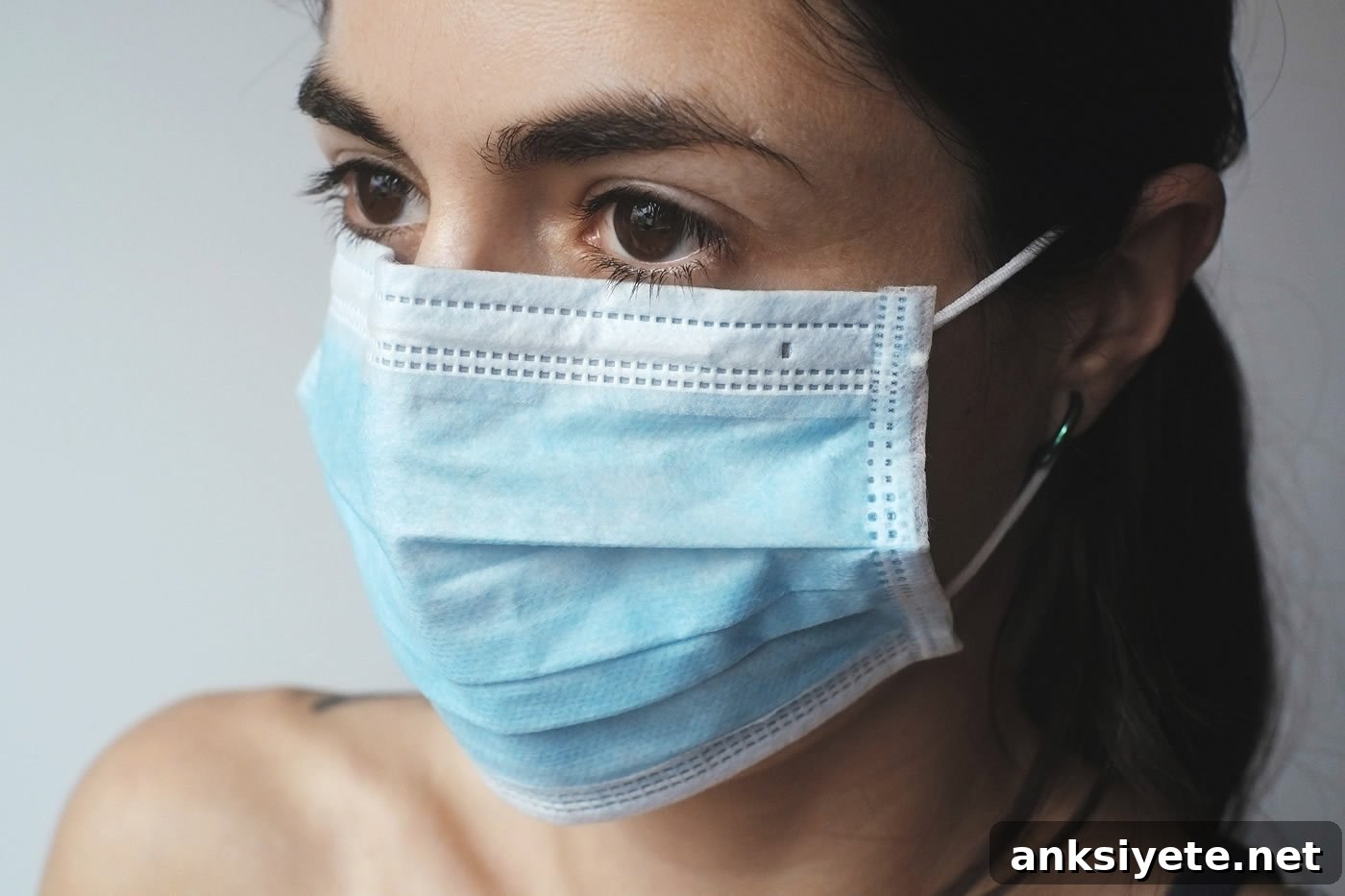 This shows a young woman in a facemask