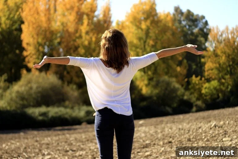 This shows a woman with her arms outstretched in a beautiful field