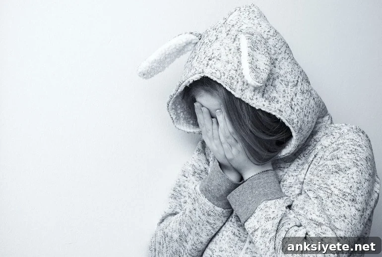 This shows a girl covering her face, looking upset