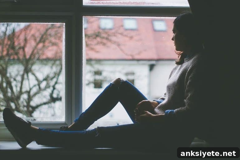 This shows a depressed looking woman sitting by a window