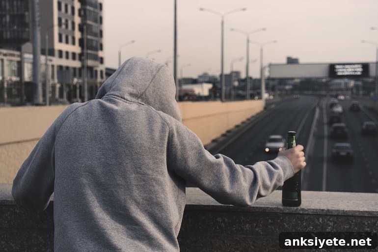 This shows a man with a bottle looking over the edge of a bridge