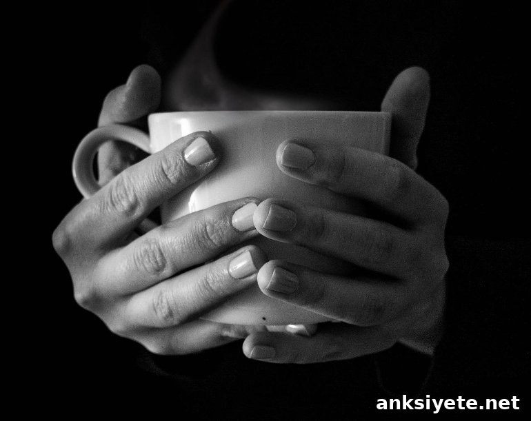 This shows a hand holding a cup of tea