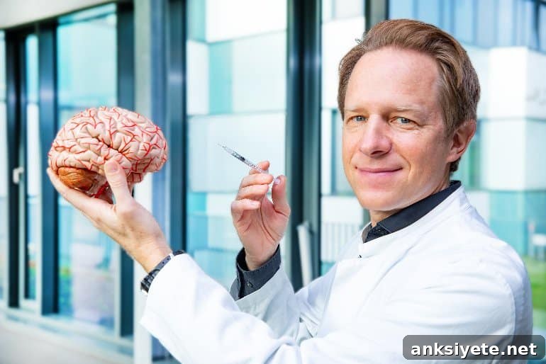 This shows the researcher holding a model of a brain and a syringe