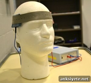 The image shows a manikin's head with a tDCS placed upon it.